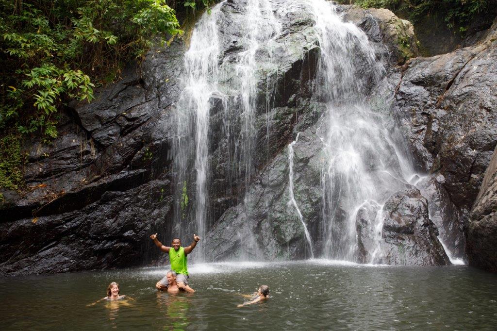Swimmers enjoy the cool water at Vuodomo waterfall, Savusavu.