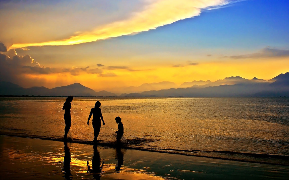 A family play on the beach at sunset near Savusavu.