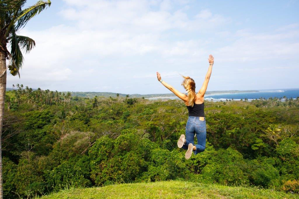 Promotional photo of a woman jumping on a hill near Savusavu