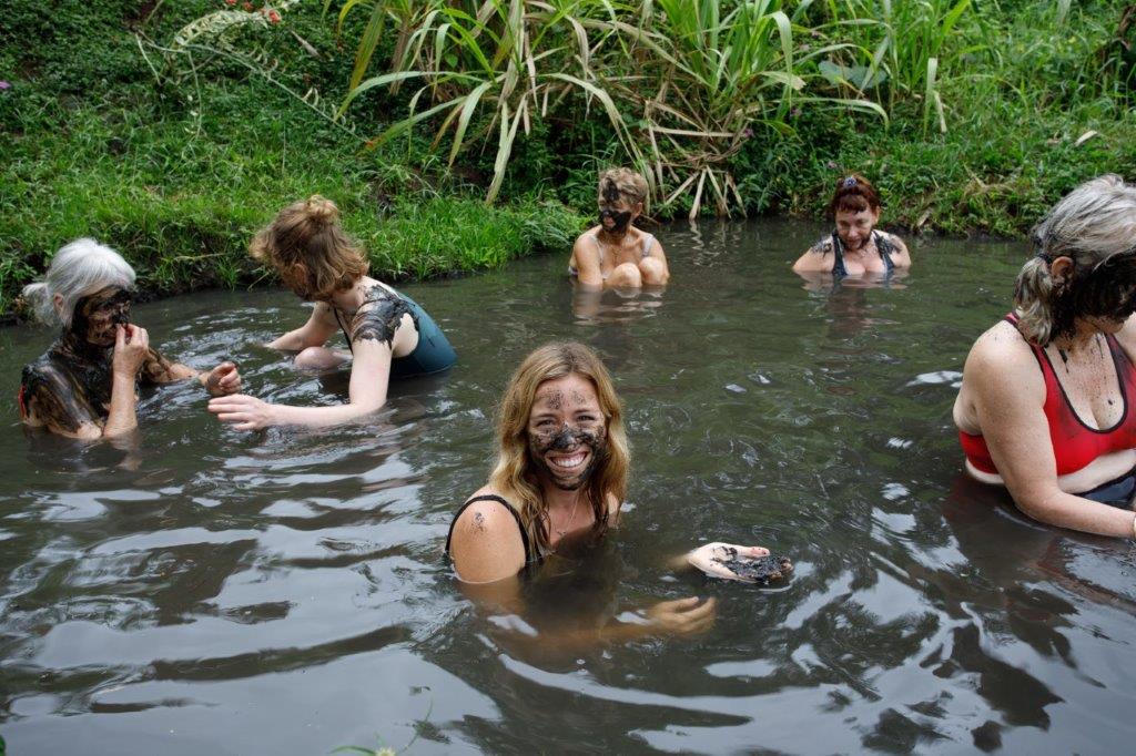 A group of tourists bathe in the local thermal mud pools